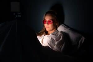 blauw licht filter bril vrouw bed telefoonlicht