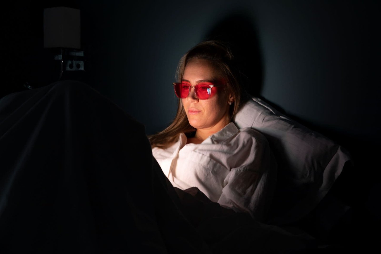 blauw licht filter bril vrouw bed telefoonlicht