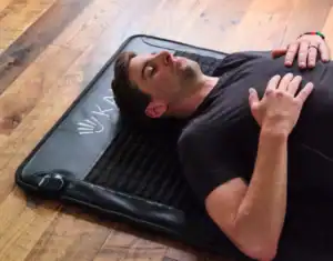 Man ligt ontspannen op een PEMF magneetveld therapie mat voor pijnverlichting en herstel.