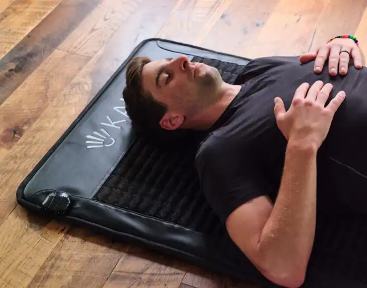 Man ligt ontspannen op een PEMF magneetveld therapie mat voor pijnverlichting en herstel.