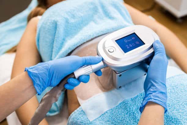 Beautician applying cryolipolysis treatment in beauty salon. cryolipolyse