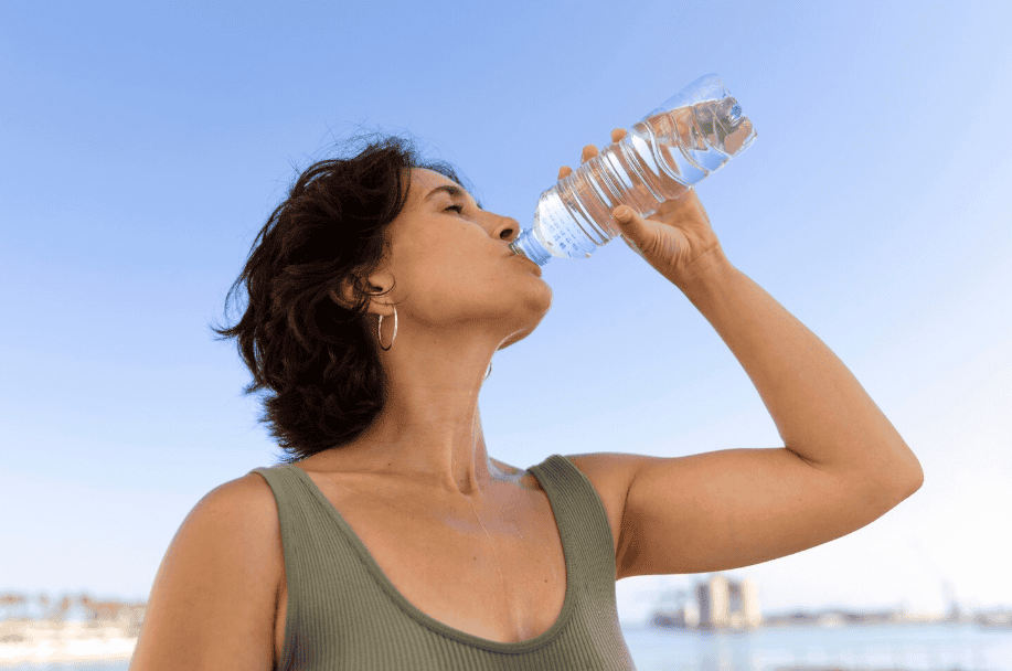 vrouw drinkt water om goed gehydrateerd te blijven middagdip