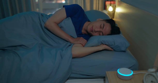 Closeup asian man lying on bed using white noise machine white noise apparaat helping sleeping quality at night